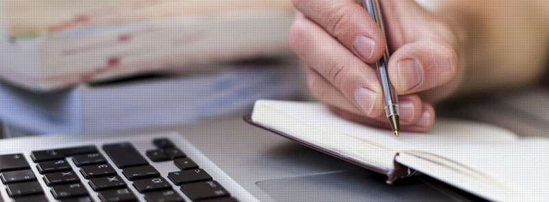 Image of Hand holding pen writing in notebook